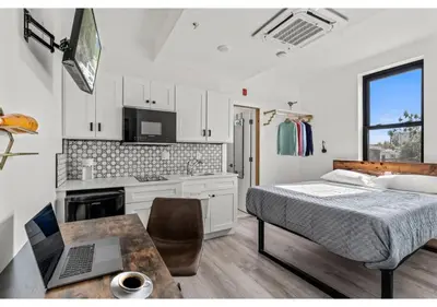 a bedroom with a bed and a desk with a laptop at Center City Philadelphia GSN Bloom 1 in Philadelphia