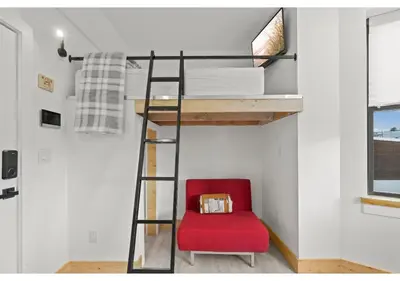 a red chair in a room with a loft bed at Temple District GSN Bloom3 in Philadelphia