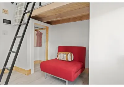a red chair in a room with a ladder at Temple District GSN Bloom3 in Philadelphia