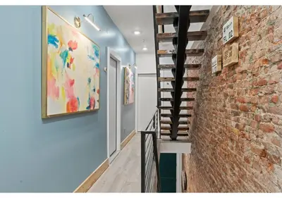 a hallway with a brick wall and a staircase at Temple District GSN Bloom3 in Philadelphia