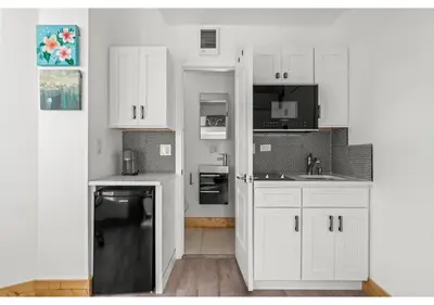 a white kitchen with white cabinets and a sink at Temple District GSN Bloom3 in Philadelphia
