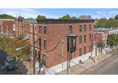a large red brick building on a city street at Temple District GSN Bloom3 in Philadelphia