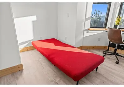 a red bed in a room with a chair at Temple District GSN Bloom3 in Philadelphia