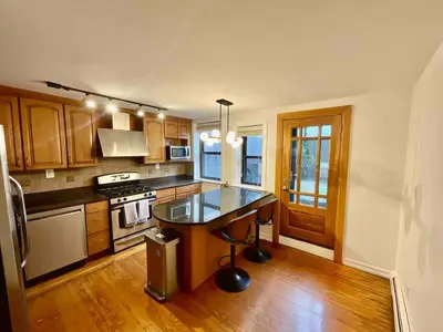 a kitchen with a island in the middle of it at VAN VORST HOUSE 2 BR Brownstone Apt Minutes to NYC in Jersey City
