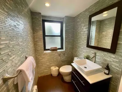 a bathroom with a sink and a toilet and a window at VAN VORST HOUSE 2 BR Brownstone Apt Minutes to NYC in Jersey City
