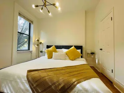 a bedroom with a large white bed with yellow pillows at VAN VORST HOUSE 2 BR Brownstone Apt Minutes to NYC in Jersey City
