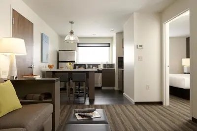 a living room and kitchen with a couch and a table at Hyatt House Monroe / Cranbury / South Brunswick in Monroe Township