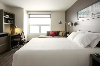 a bedroom with a large white bed and a desk at Hyatt House Monroe / Cranbury / South Brunswick in Monroe Township