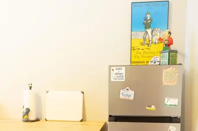 a refrigerator with magnets and a poster on top of it at Private 2-Bedroom Second-Floor Residence, Bala Cynwyd in Bala-Cynwyd