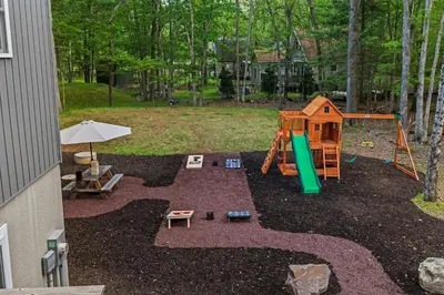 a backyard with a playground with a slide and a play structure at Cozy Poconos Chalet Sauna, Hot Tub, Game Room in Albrightsville