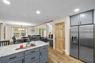 a kitchen with a large stainless steel refrigerator and a living room at Cozy Poconos Chalet Sauna, Hot Tub, Game Room in Albrightsville