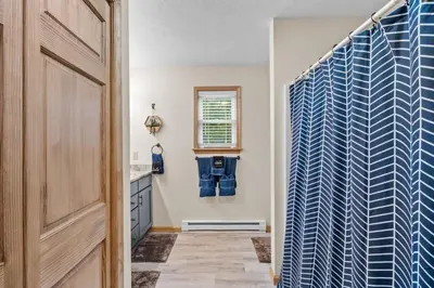 a bathroom with a blue and white shower curtain at Cozy Poconos Chalet Sauna, Hot Tub, Game Room in Albrightsville