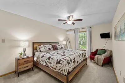 a bedroom with a bed and a ceiling fan at Cozy Poconos Chalet Sauna, Hot Tub, Game Room in Albrightsville