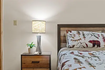 a bedroom with a bed and a lamp on a night stand at Cozy Poconos Chalet Sauna, Hot Tub, Game Room in Albrightsville