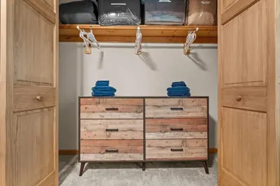a closet with wooden cabinets and a dresser at Cozy Poconos Chalet Sauna, Hot Tub, Game Room in Albrightsville
