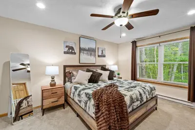 a bedroom with a bed and a ceiling fan at Cozy Poconos Chalet Sauna, Hot Tub, Game Room in Albrightsville