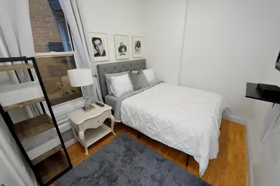 a small bedroom with a bed and a window at Cityscape 2 Bedroom Unit Prime Location in New York