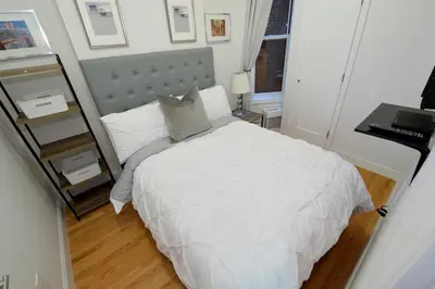 a bedroom with a white bed and a desk at Cityscape 2 Bedroom Unit Prime Location in New York