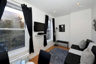 a living room with a couch and a tv and a window at Cityscape 2 Bedroom Unit Prime Location in New York