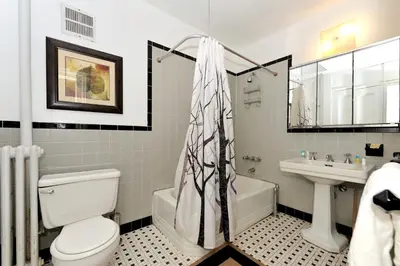 a bathroom with a white toilet and a sink at Comfy 3 Bedroom 2 Bath Apartment in NYC in New York