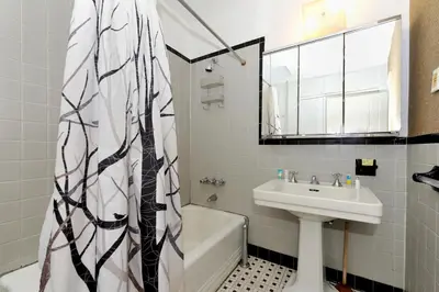 a bathroom with a sink and a shower curtain at Comfy 3 Bedroom 2 Bath Apartment in NYC in New York