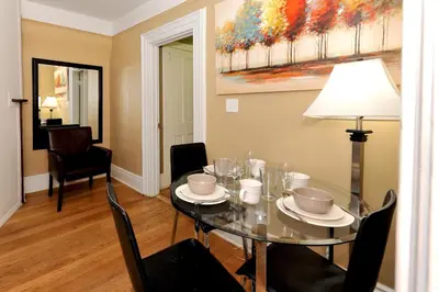 a dining room with a glass table and chairs at Comfy 3 Bedroom 2 Bath Apartment in NYC in New York