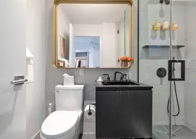 a bathroom with a toilet and a sink and a mirror at Alluring and Spacious 1 Bed 1 Bath Apt in New York