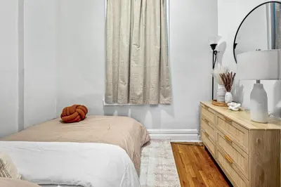a bedroom with a bed and a mirror and a dresser at Bright and Beautiful 3 BR Apt Midtown West in New York