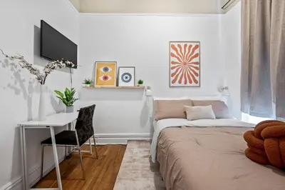 a bedroom with a bed and a desk and a tv at Bright and Beautiful 3 BR Apt Midtown West in New York