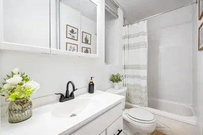 a white bathroom with a sink and a toilet at Bright and Beautiful 3 BR Apt Midtown West in New York