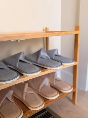 a wooden shelf with a bunch of shoes on it at Luxury Catskills Sauna Retreat -Haven On The Manor in Livingston Manor