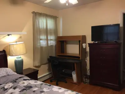 a bedroom with a bed and a television and a desk at Fully furnished unit for rent in Wilmington