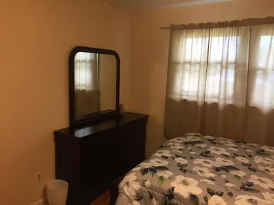 a bedroom with a bed and a mirror on a dresser at Fully furnished unit for rent in Wilmington