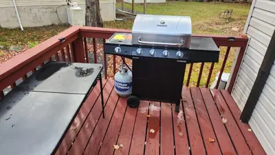 a grill and a picnic table on a deck at Cozy Cabin in Tobyhanna