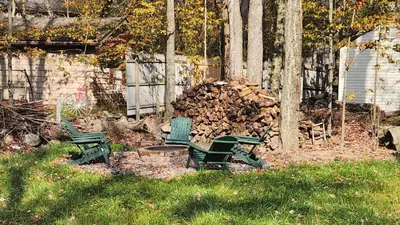 two green benches sitting next to a pile of wood at Cozy Cabin in Tobyhanna