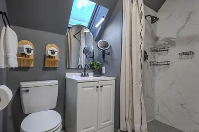 a bathroom with a white toilet and a shower at Summit Home - The Ultimate Summit of Style for 12 in Tobyhanna