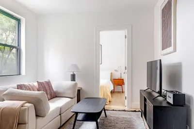 a white living room with a couch and a tv at Blueground Murray Hill washer nr Bryant Park NYC-1870 in New York