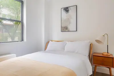 a white bedroom with a bed and a window at Blueground Murray Hill washer nr Bryant Park NYC-1870 in New York