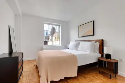 a bedroom with a large bed and a window at Blueground Hells Kitchen washer nr Times Square NYC-2074 in New York