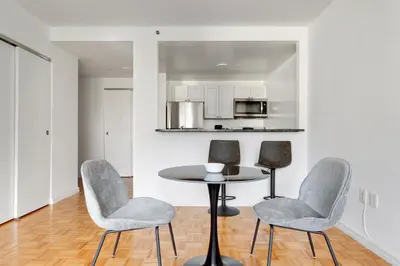 a dining room with a table and chairs and a kitchen at Blueground Hells Kitchen washer nr Times Square NYC-2074 in New York