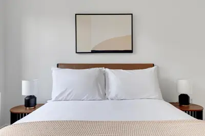 a bedroom with a white bed with two lamps at Blueground Hells Kitchen washer nr Times Square NYC-2074 in New York