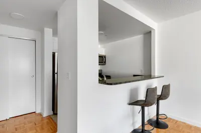 a room with two chairs and a wall with a mirror at Blueground Hells Kitchen washer nr Times Square NYC-2074 in New York