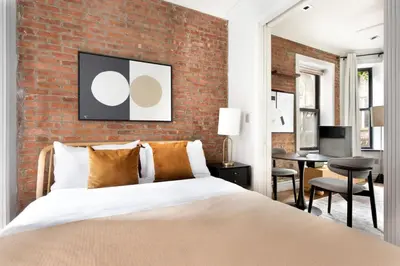 a bedroom with a brick wall and a bed at Blueground West Village terrace nr Hudson River Park NYC-2123 in New York