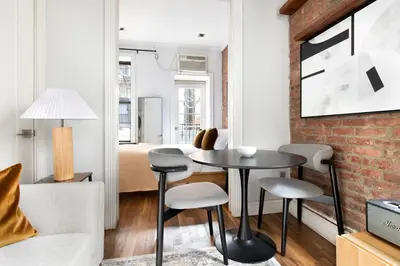 a living room with a table and chairs and a bedroom at Blueground West Village terrace nr Hudson River Park NYC-2123 in New York