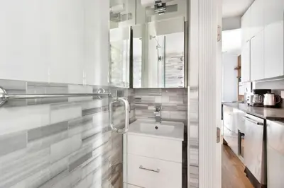 a white kitchen with a sink and a counter at Blueground West Village terrace nr Hudson River Park NYC-2123 in New York