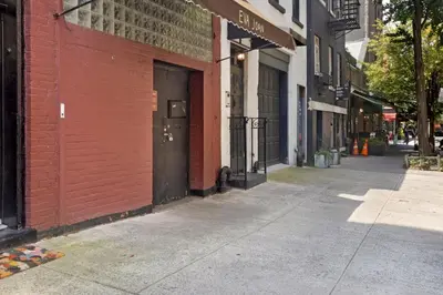 an empty street with a red brick building and a door at Blueground West Village view nr Hudson River NYC-1933 in New York