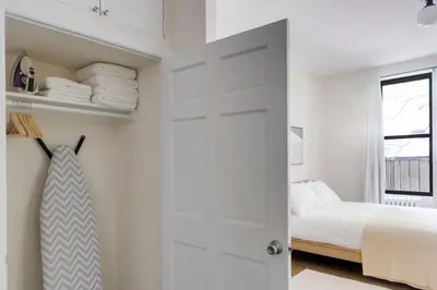 a white bedroom with a bed and a door at Blueground West Village view nr Hudson River NYC-1933 in New York