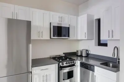 a white kitchen with a stove and a microwave at Blueground West Village view nr Hudson River NYC-1933 in New York