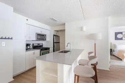 a kitchen with white cabinets and a counter top at Blueground Hudson Exchange pool nr Liberty Park NYC-2222 in New York