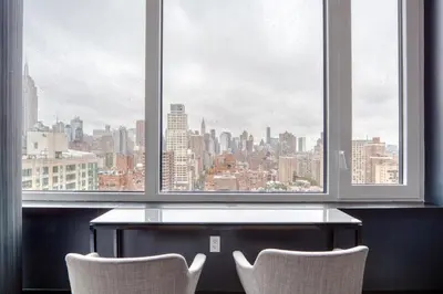 a table and two chairs in front of a window at Blueground Gramercy Park rooftop nr Flatiron NYC-2203 in New York